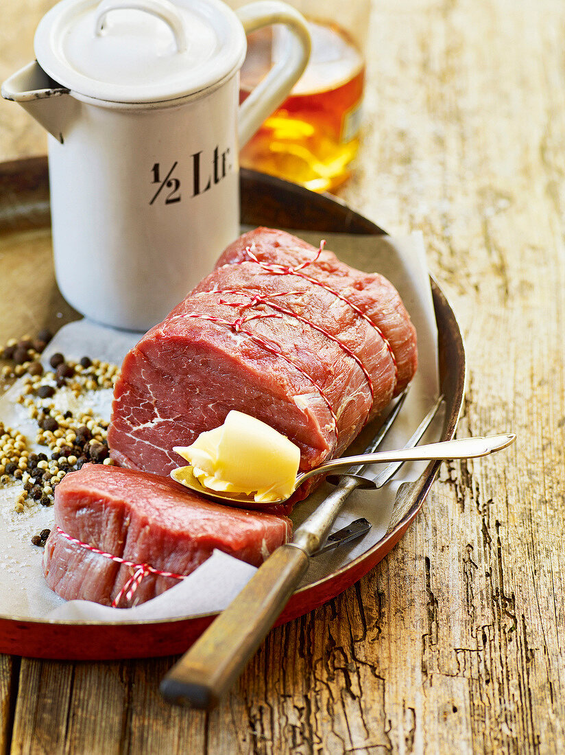 Beef, butter, black pepper and tea pot on tray, France