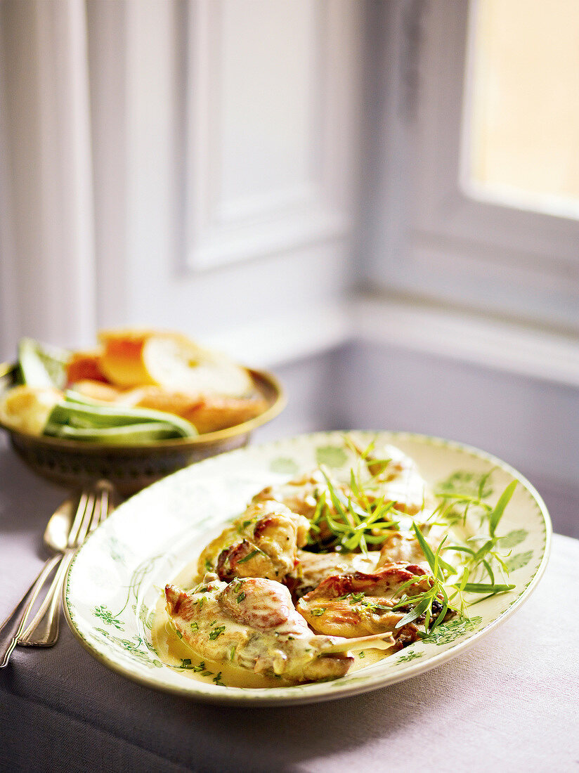 Rabbit in mustard sauce garnished with tarragon on plate, France