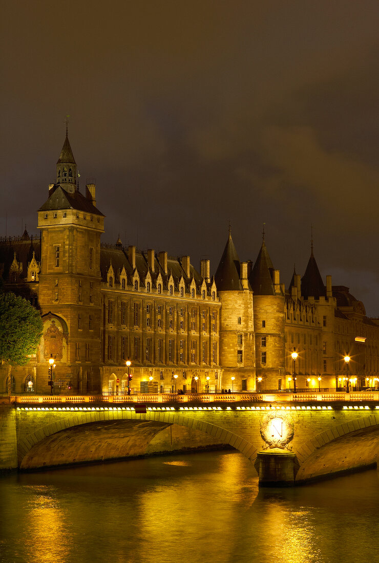 Illuminated Pont au Change bridge at evening in Paris, France