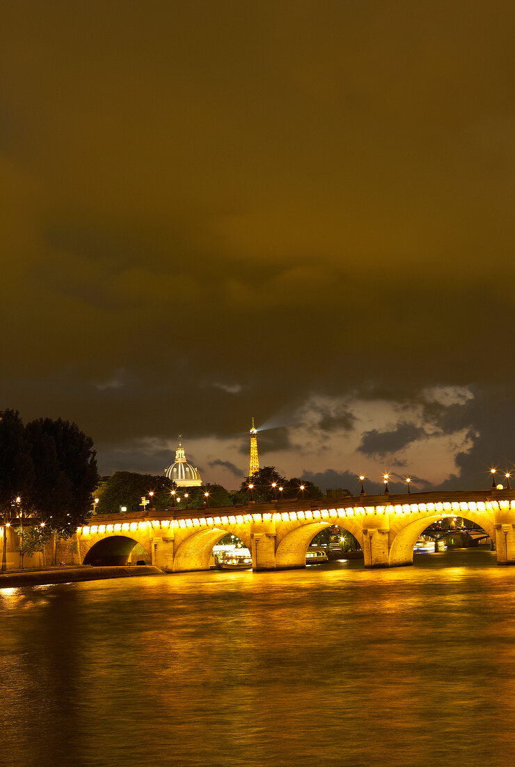 Illuminated Pont au Change bridge at evening in Paris, France