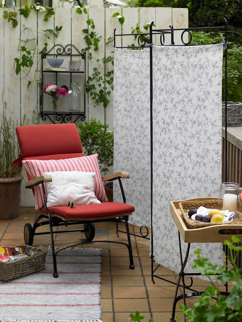 Screen-covered with fabric, iron furniture and armchair on balcony