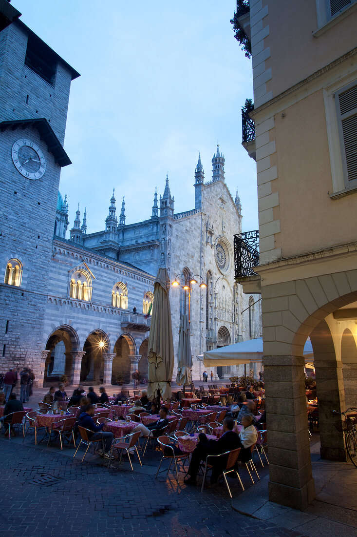 People sitting in cafe in Piazza outside cathedral, Lombardy, Italy