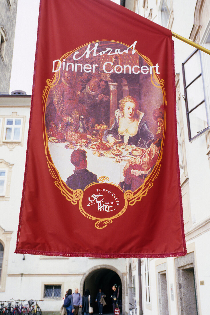 Flag with a restaurant name hanging outside St Peter Monastery in Salzburg, Austria