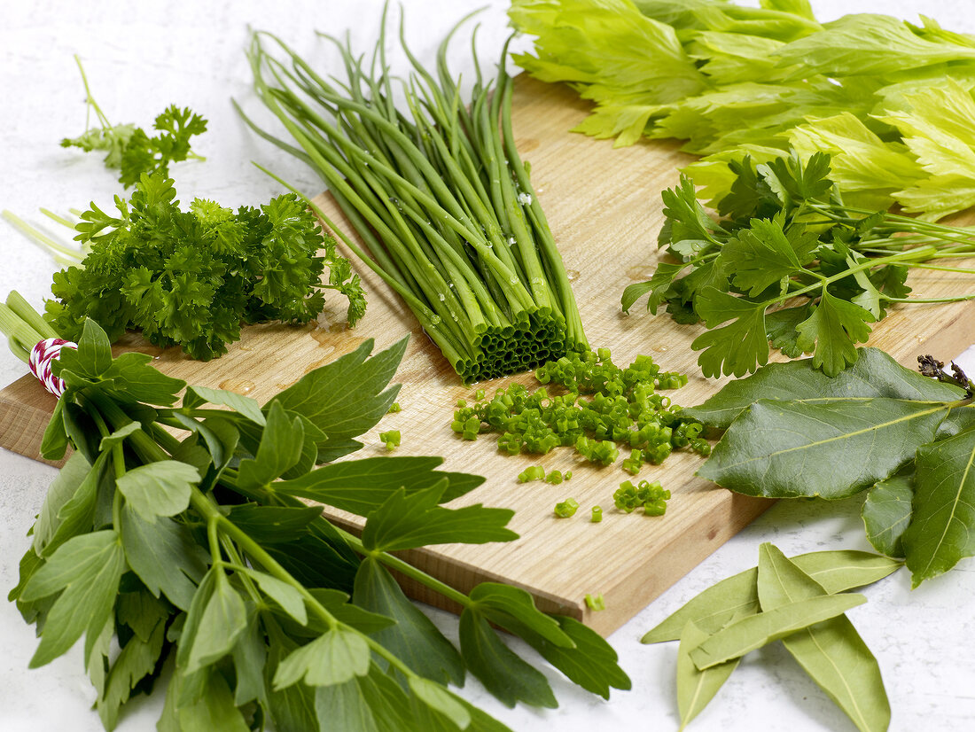 Different types of fresh herbs on chopping board