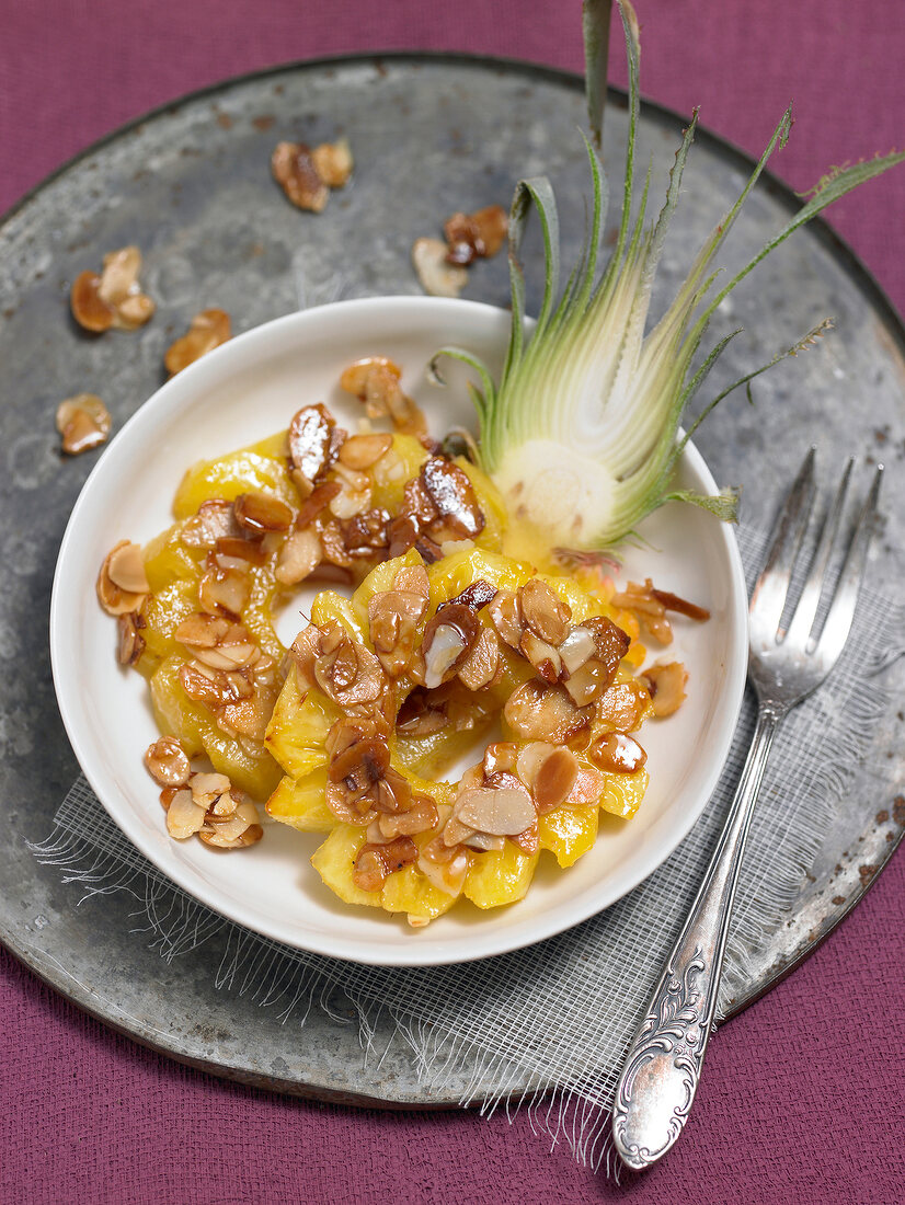 Bowl of pineapple and almonds on tray