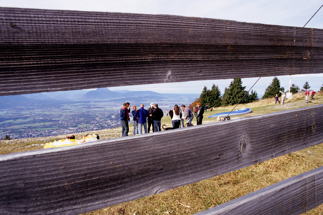 Group of paragliders seen through wooden fence at Gaisberg, Salzburg, Austria