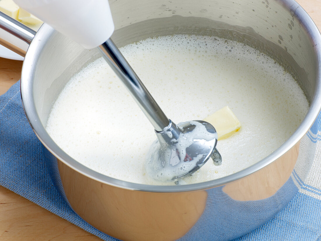 Adding butter to blended broth in pan for preparation of sauce, step 3