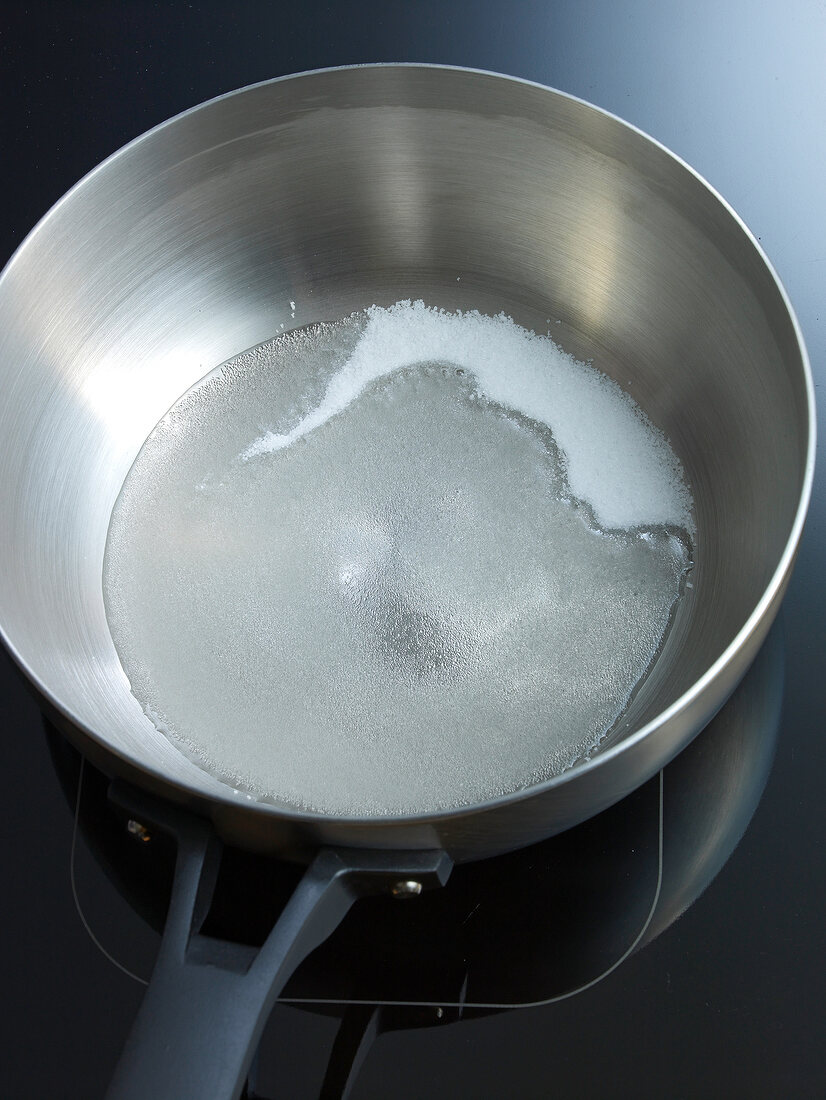 Sugar and water in pan for preparation of caramel, step 1