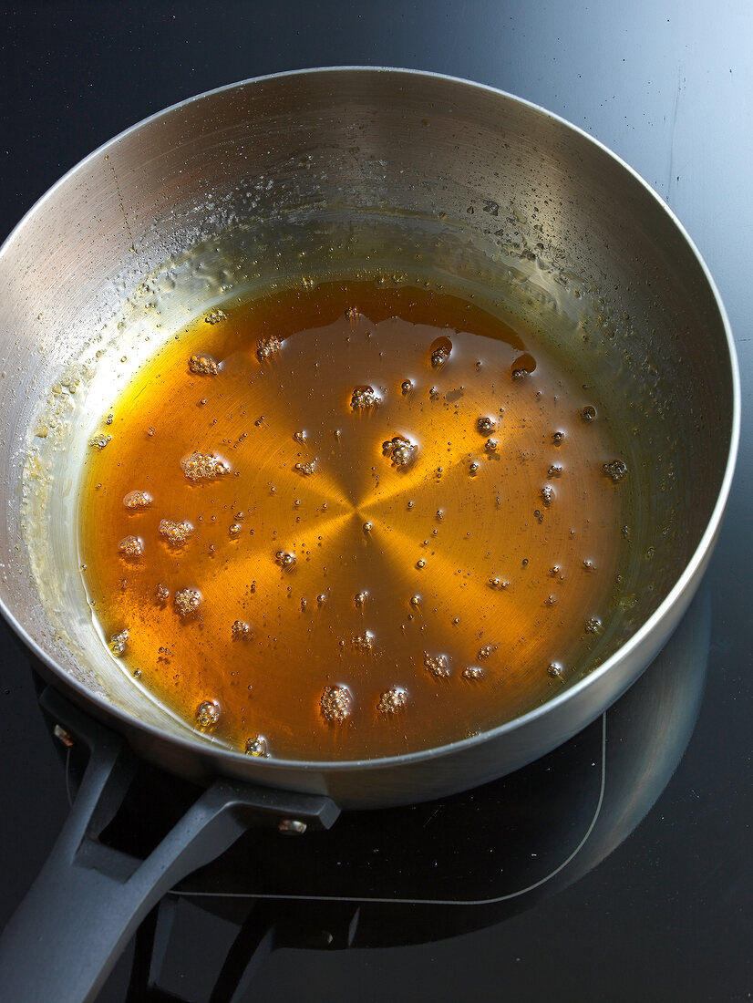 Boiled sugar and water in pan for preparation of caramel, step 4
