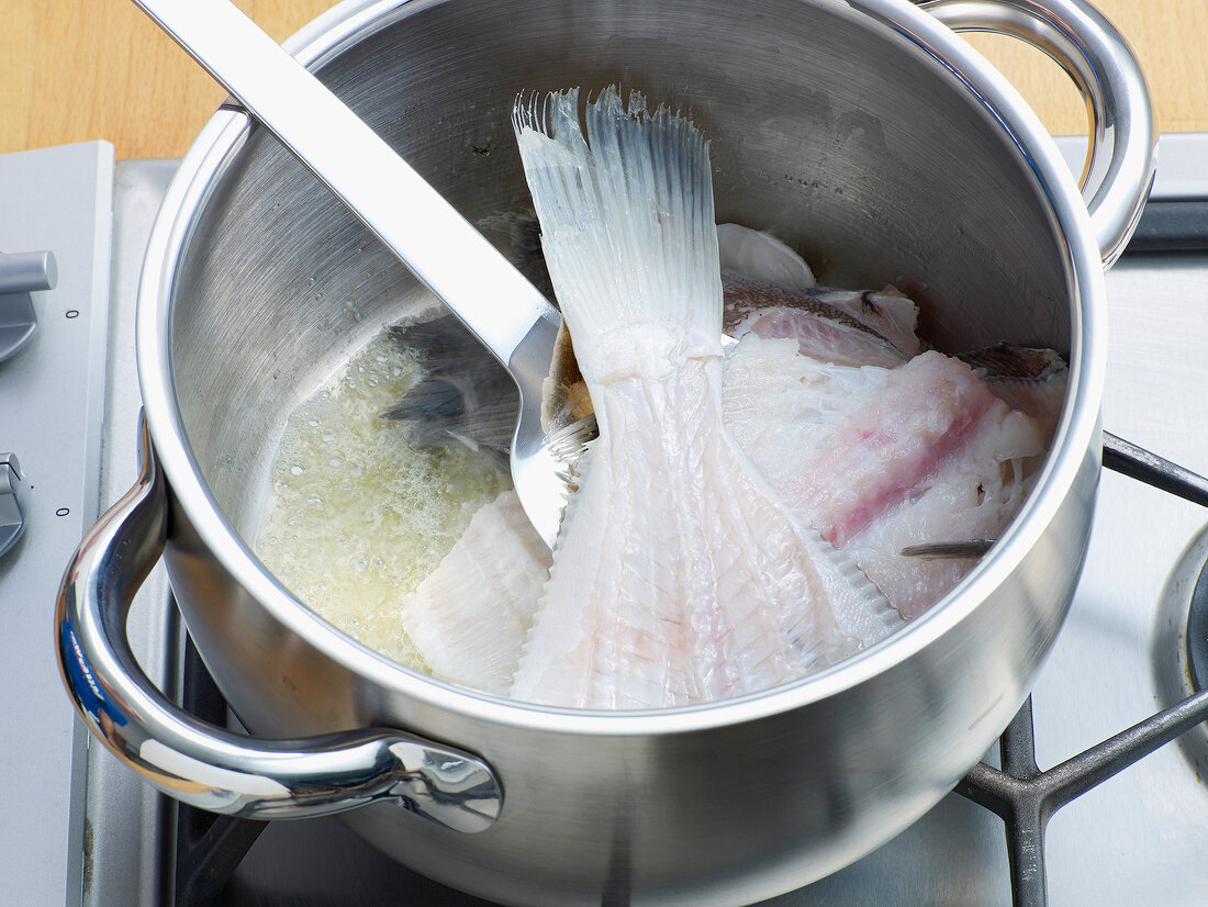 Adding fish in pan for preparation of fish stock, step 2