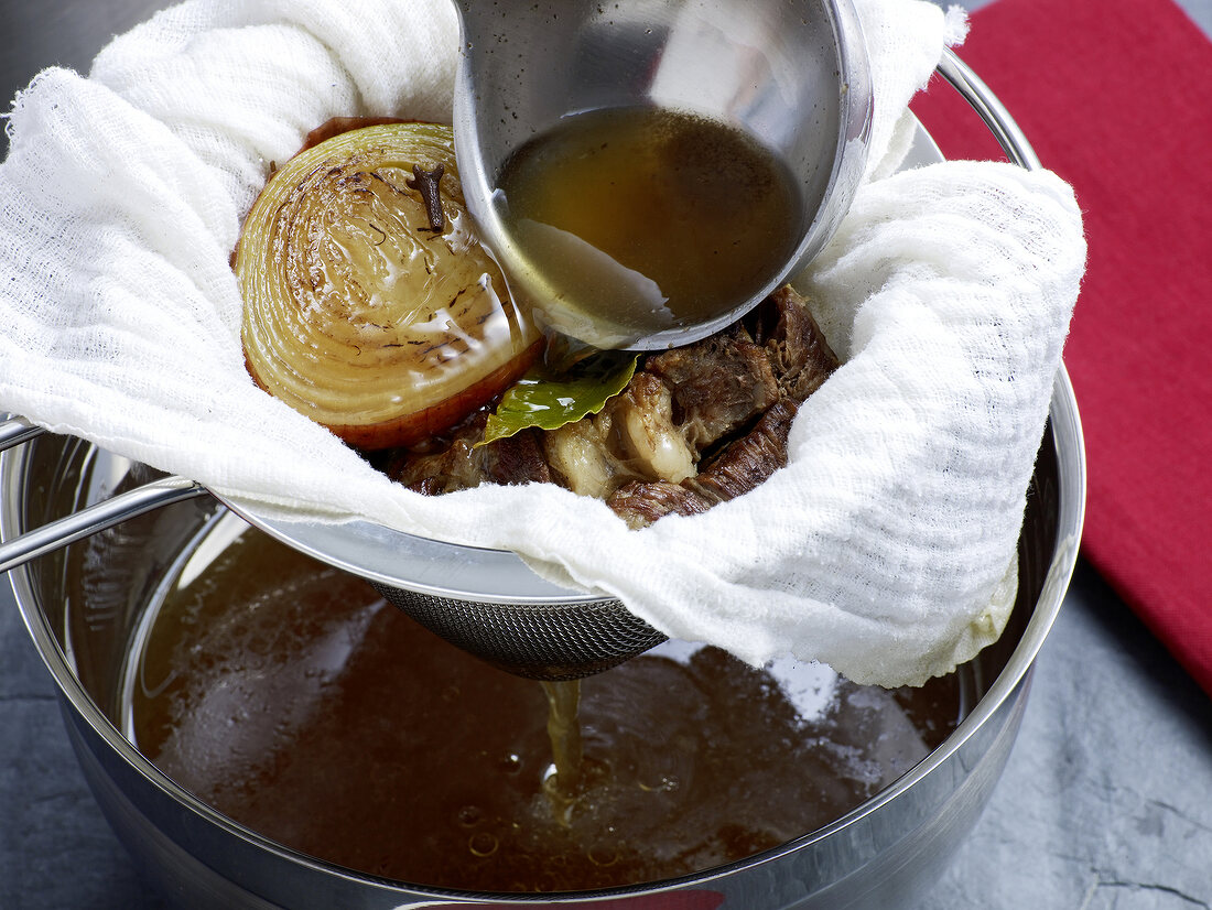 Close-up of stock being filtered with sieve, step 6