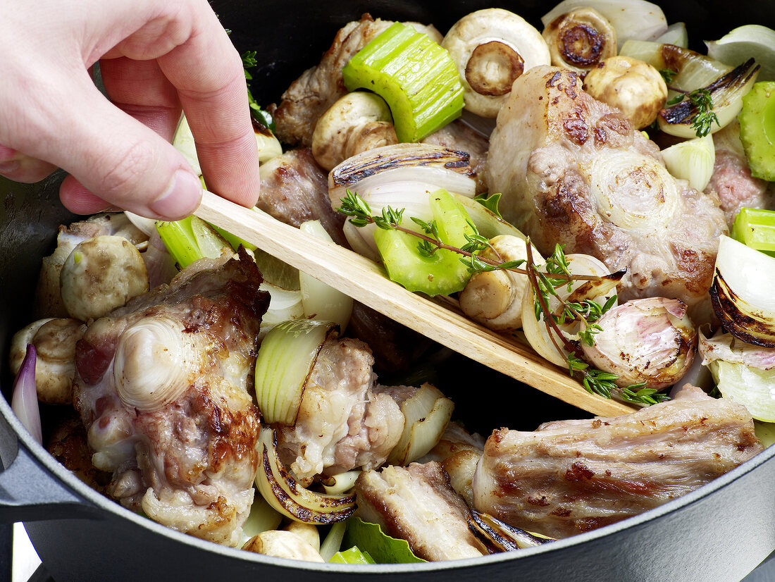 Hand stirring vegetable-veal mixture for preparation of veal jus, step 4