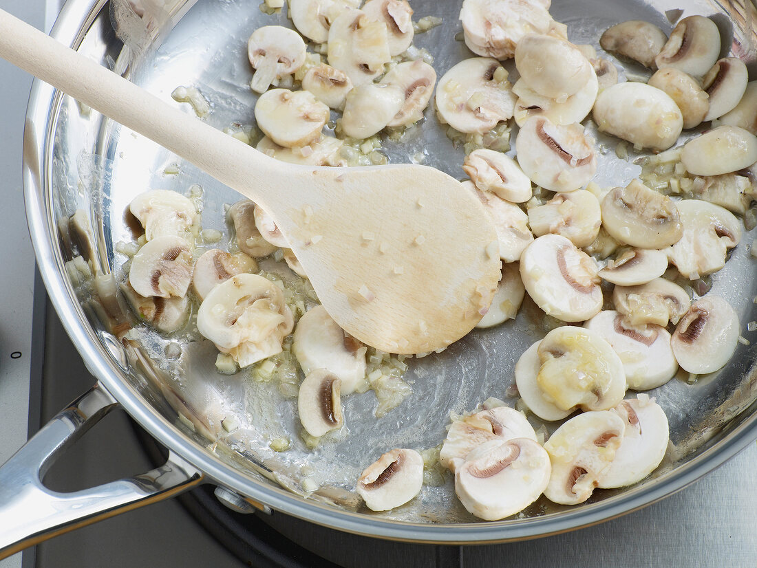 Close-up of mushrooms being saute in pan, step 1