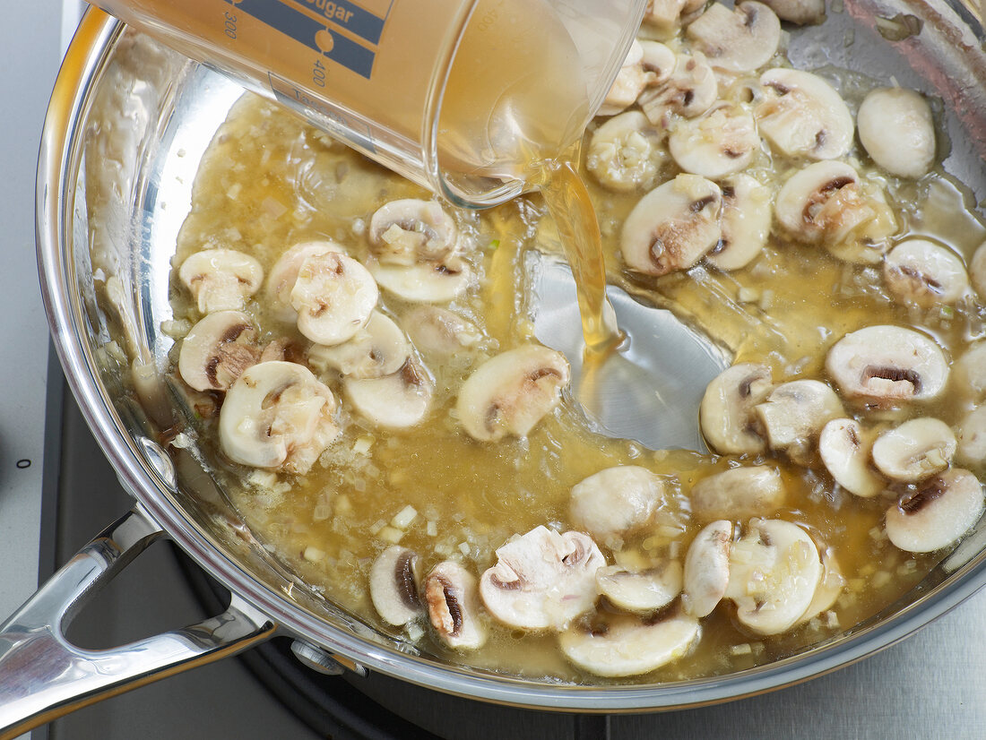 Close-up of liquid being added in mushrooms for reduction, step 2