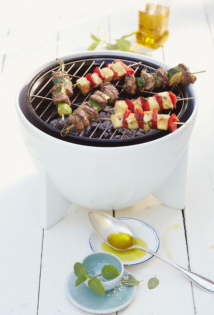 Lamb skewers and halloumi skewers on a barbecue