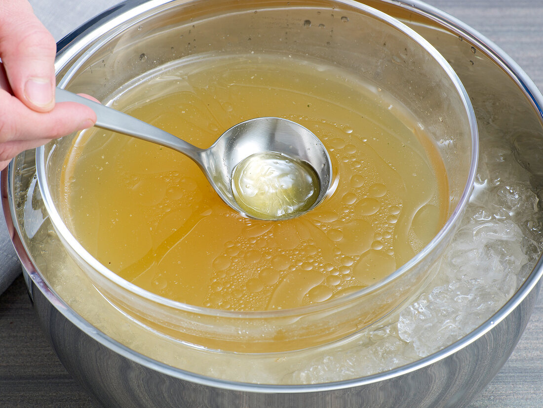 Removing oil with spoon from chicken stock, step 7