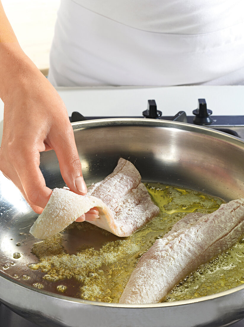 Close-up of fish fillets being fried in pan