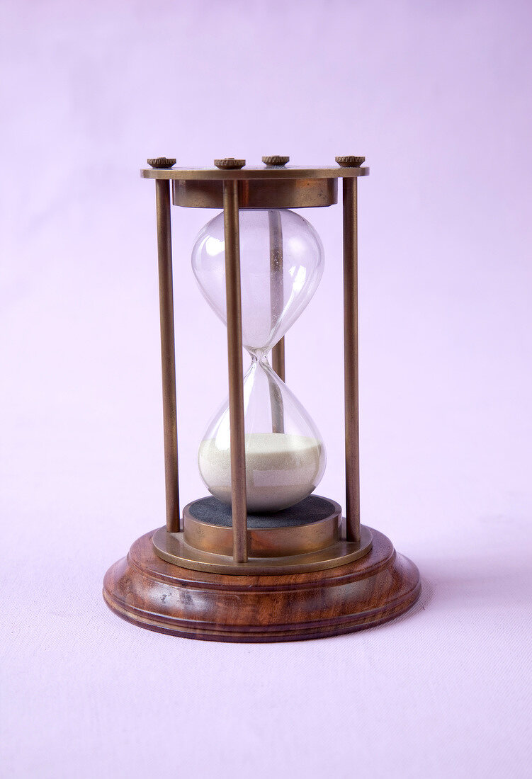 Wooden hourglass on pink background