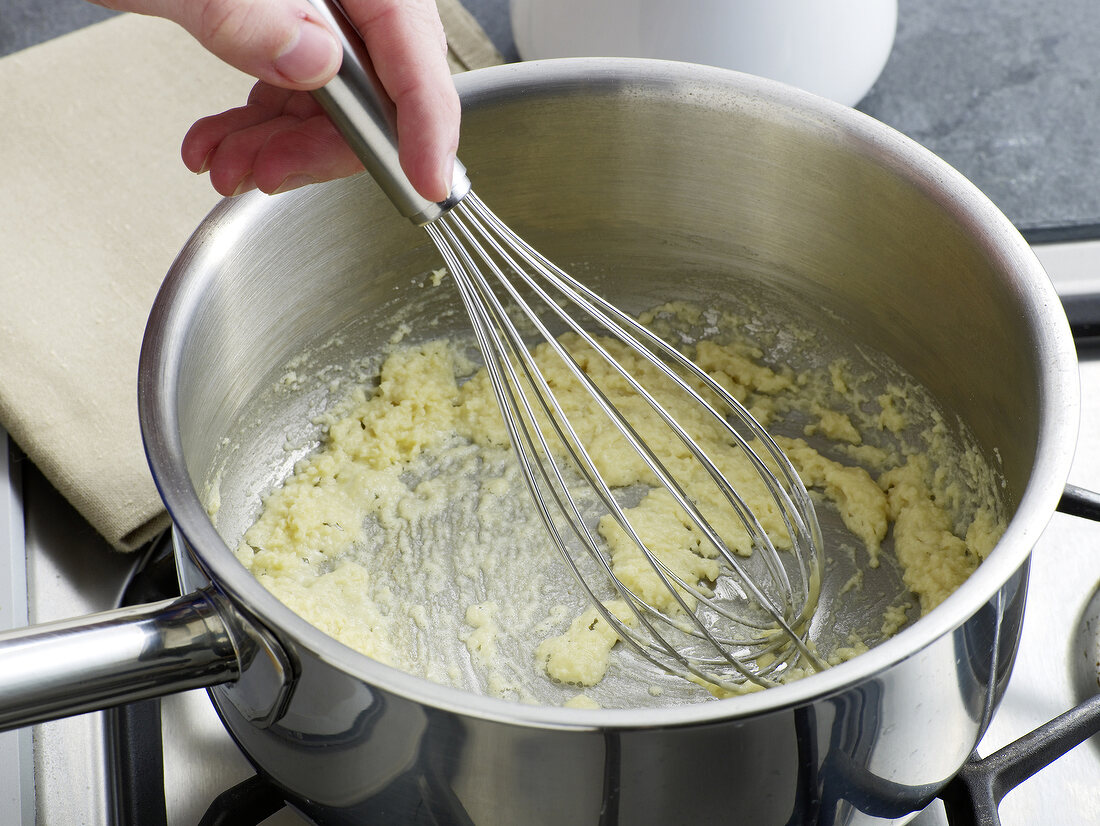 Mixture being stirred in saucepan for preparation of bechamel sauce, step 2