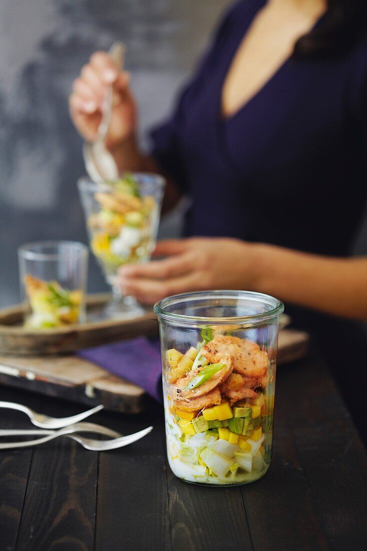 A layered salad with endives, chicken breasts, mango and avocado