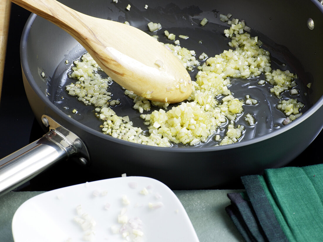 Close-up of ingredients being stirred for preparation of tomato concasse, step 2