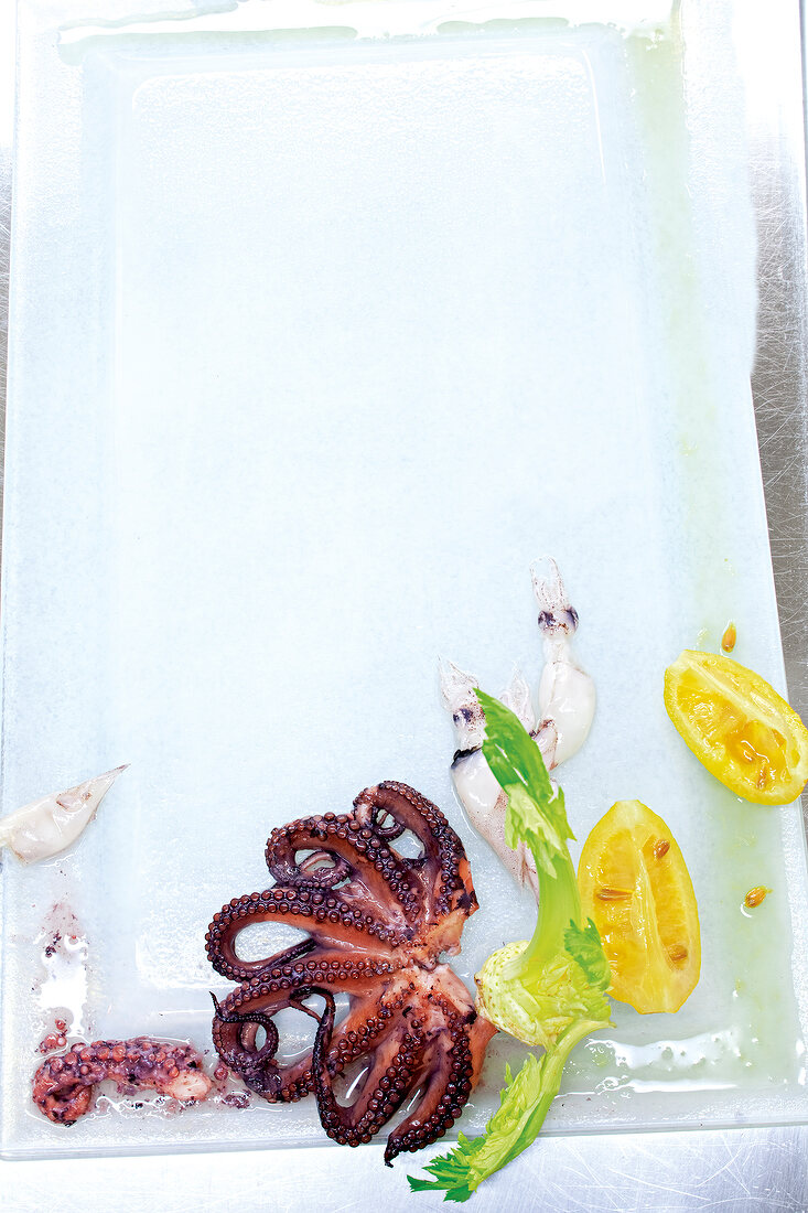 Pulpo, celery and lemon on chopping plate