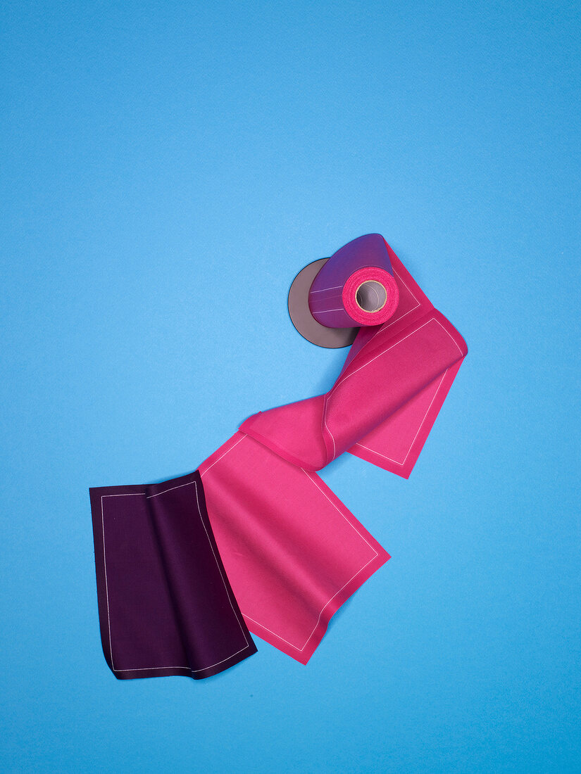 Pink and purple roll cotton napkin on blue background