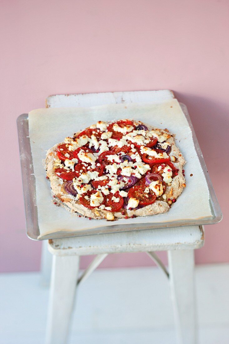 A wholemeal pizza with tomatoes, goat's cream cheese and honey