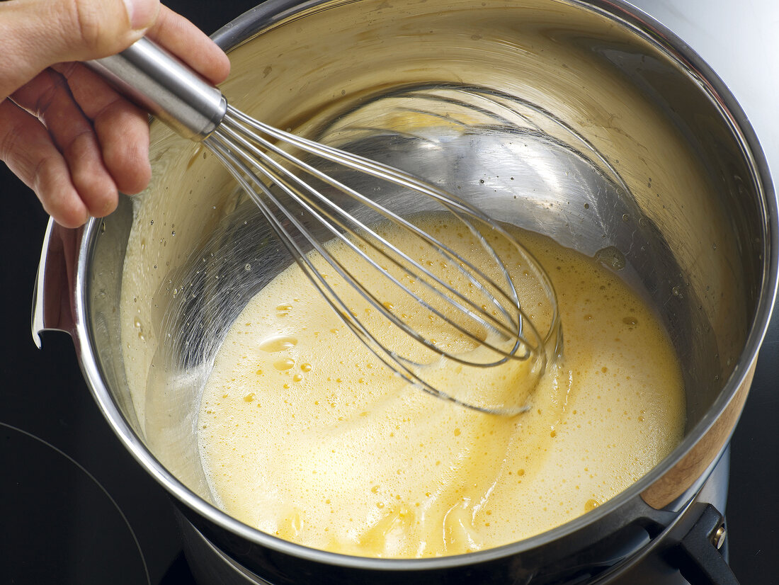 Close-up of hand whisking mixture of champagne sabayon, step 4