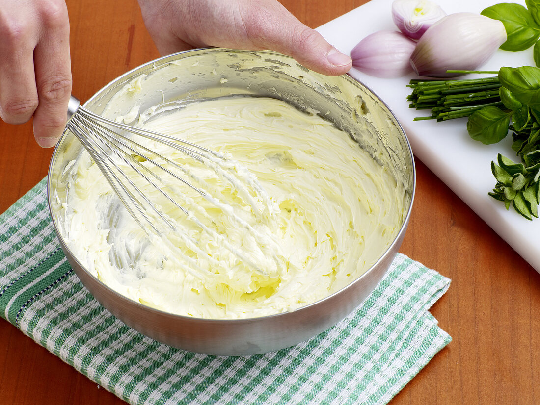 Close-up of hand whisking butter, step 1