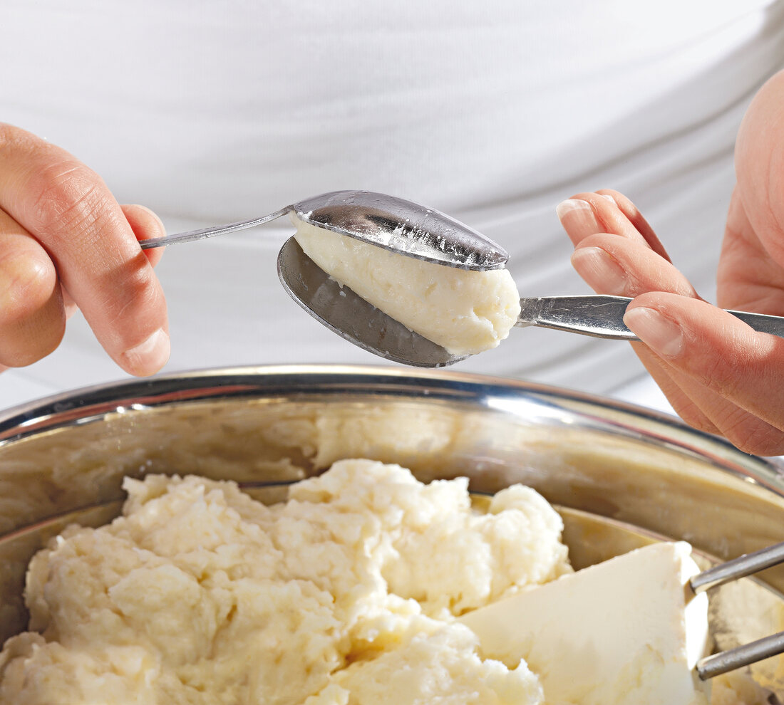 Close-up of hand mixing batter for preparation of fish balls