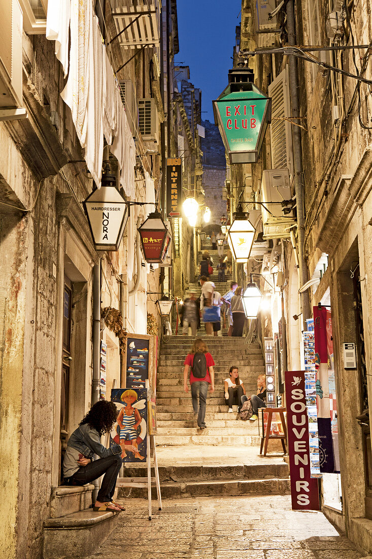 People at Dubrovnik old town alley and stairs in Croatia, in Evening