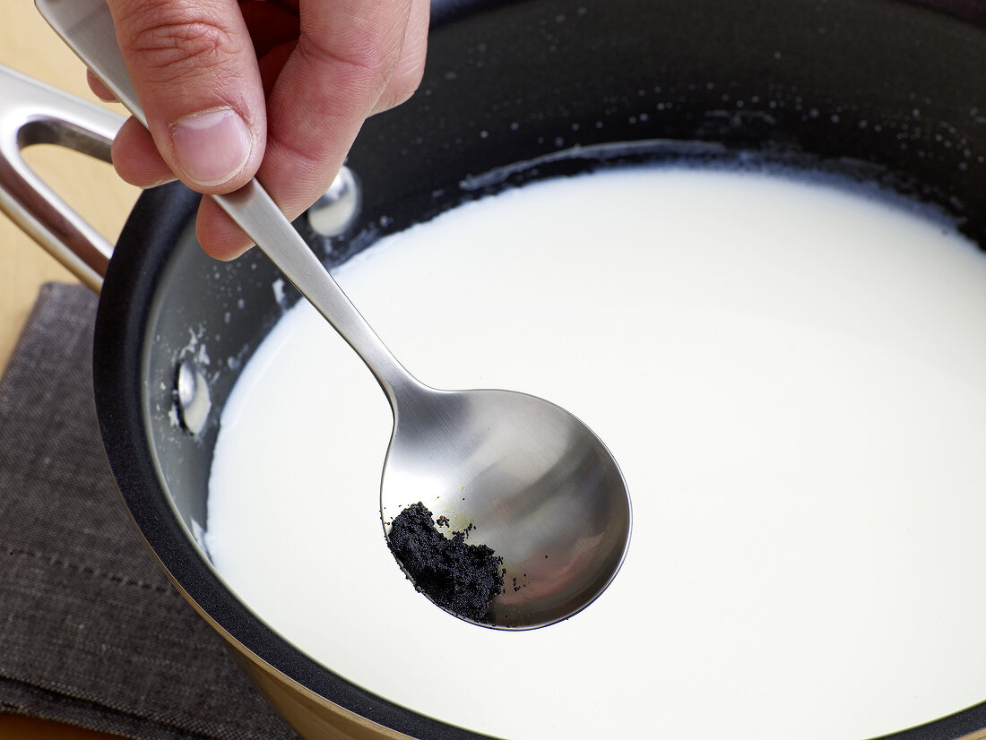 Vanilla being added in milk for preparation of vanilla sauce, step 2