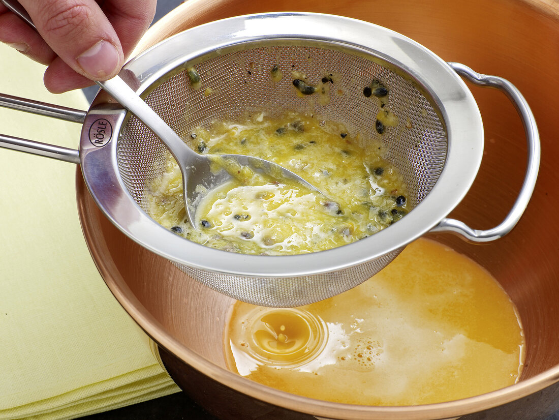 Passion fruit seeds being strained through sieve for passion fruit sabayon, step 3