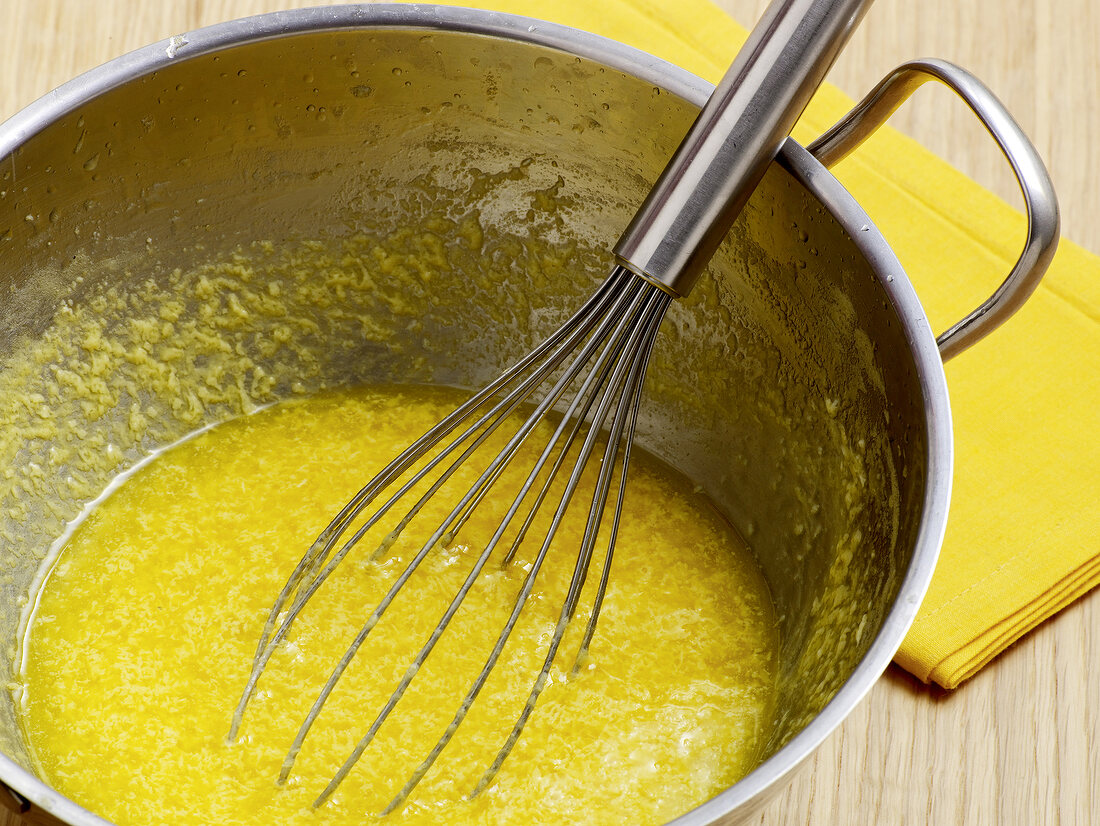 Close-up of congealed sauce being whisked in wok