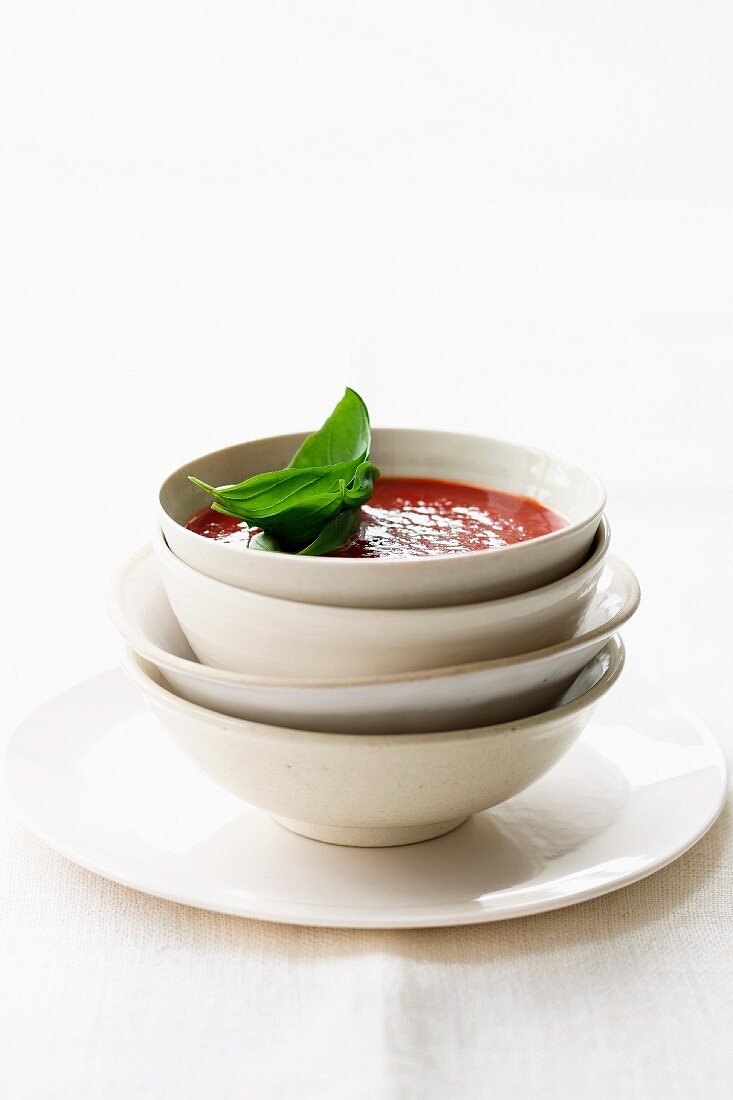 Tomatensuppe in Schälchen vor weißem Hintergrund