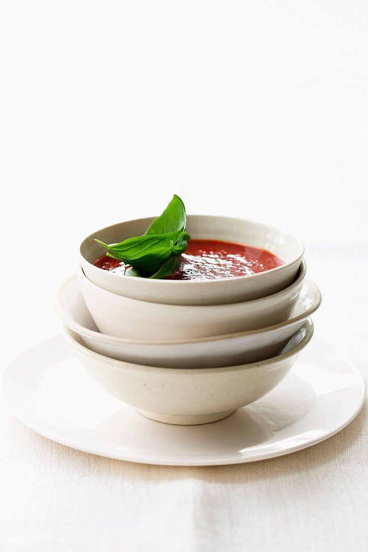 Tomato soup in a bowl against a white background