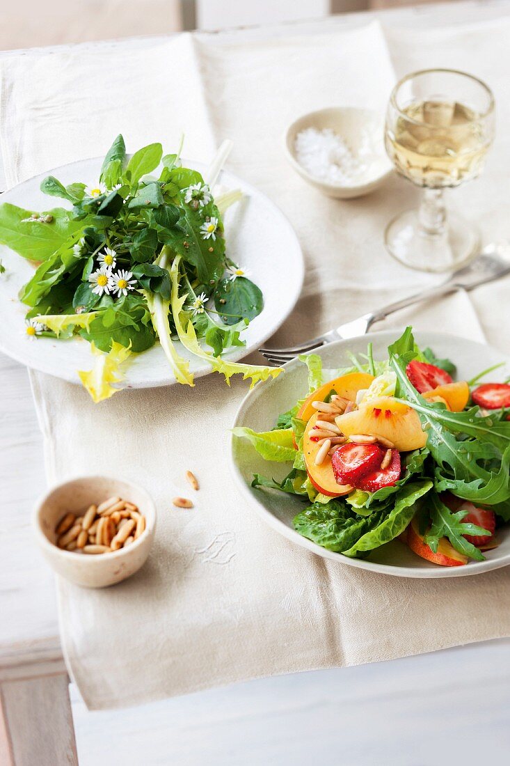 Two summer salads: wild herb salad, and a mixed leaf salad with fruits