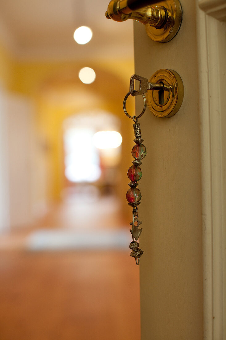 Close-up of door's keyhole with key hanging in lock