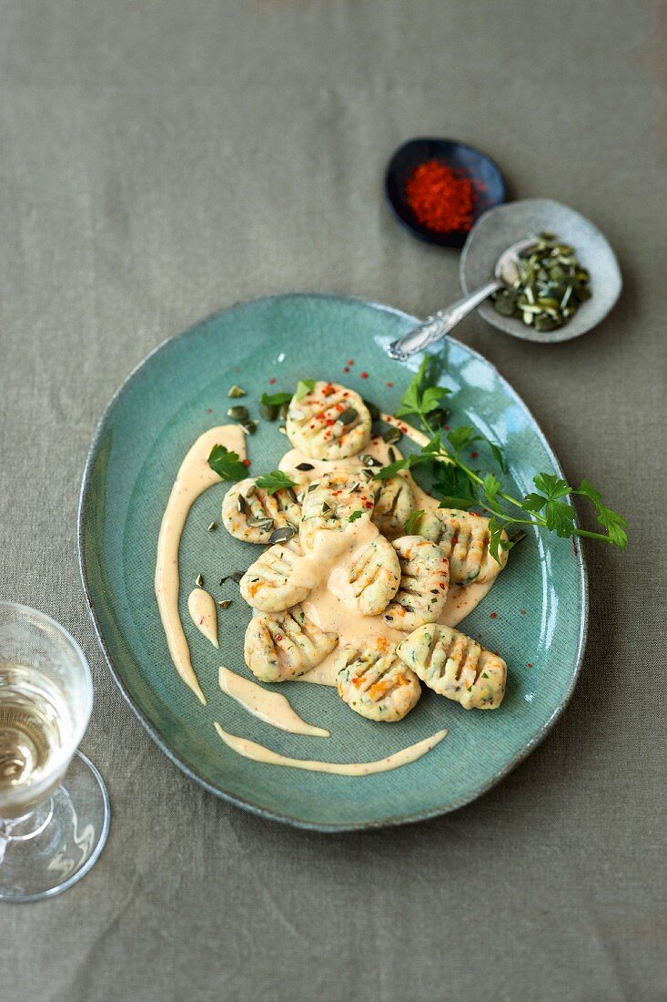 Carrot gnocchi with parsley served with a cheese sauce with chilli