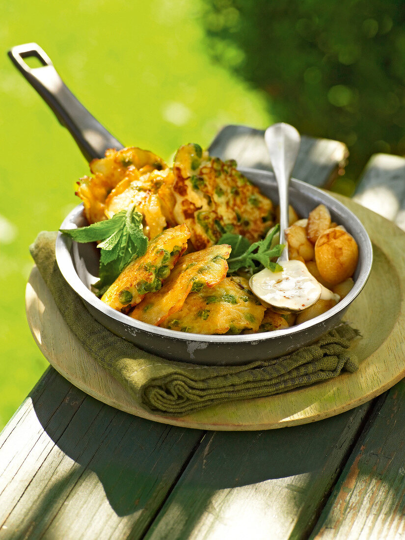 Peas rice cakes with mint and garlic in pan, garden kitchen