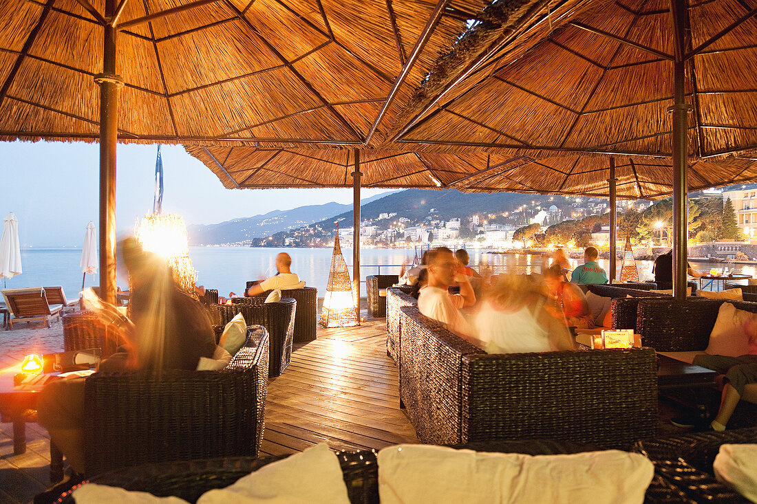 Guest at Opatija Restaurant Lido terrace in evening, Croatia