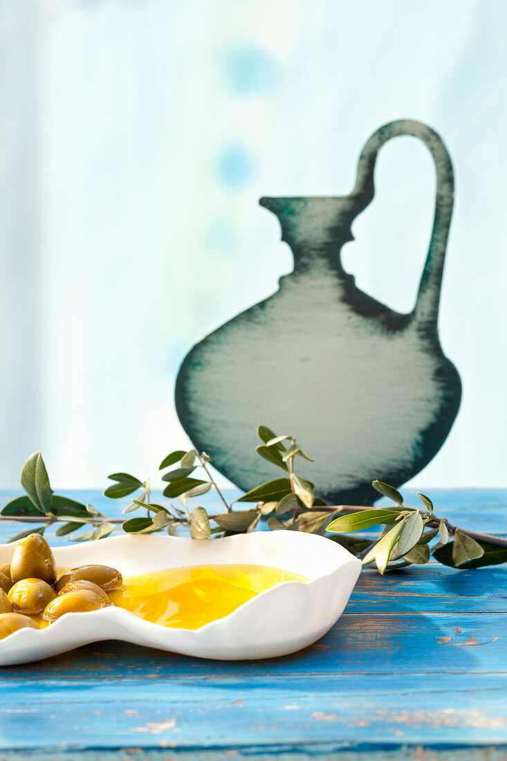 Olive, olive oil and olive branch on wood