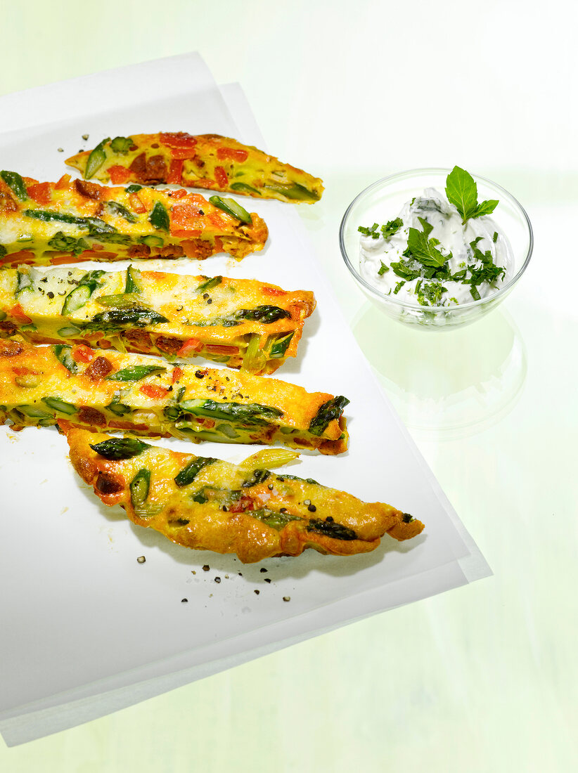 Frittata of green asparagus and grilled peppers on chopping board