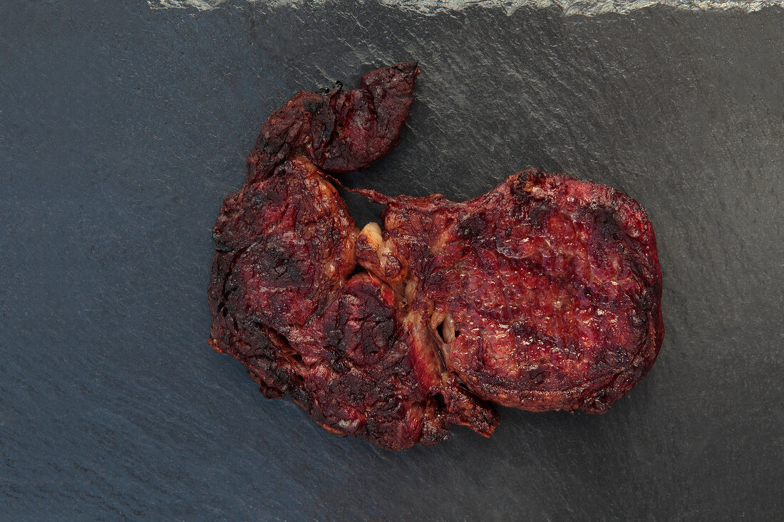 Close-up of roasted steak on black background