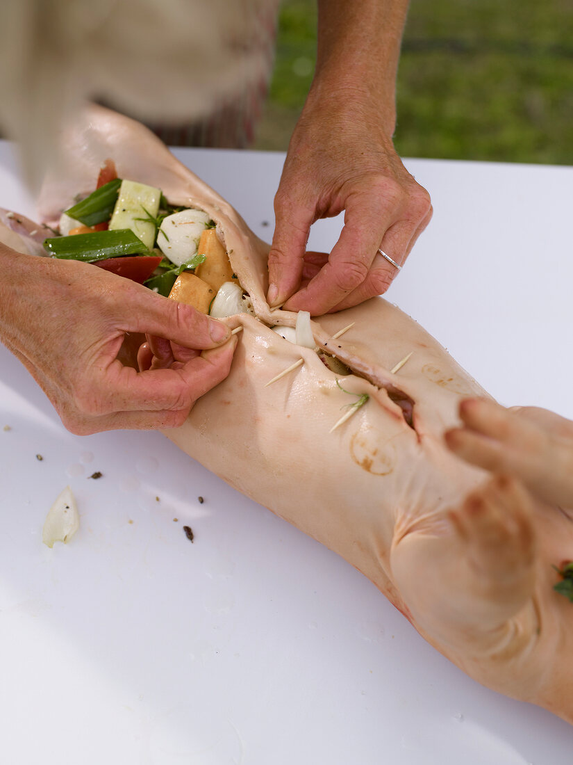 Close-up of suckling pig being stuffed with vegetables