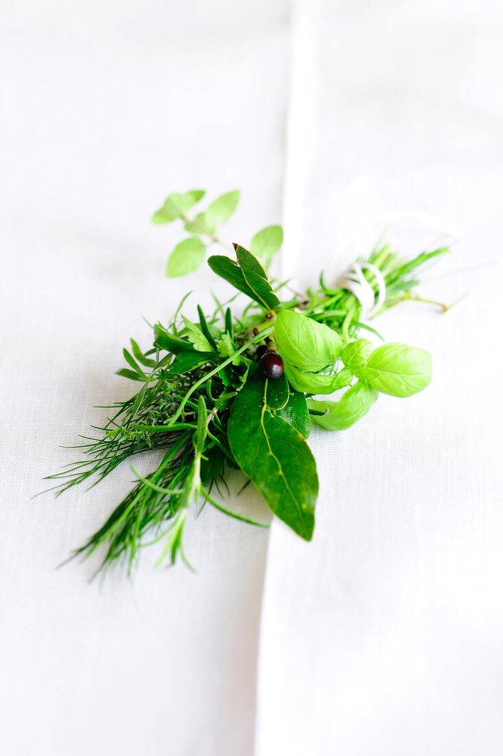 Fresh green herbs on white cloth