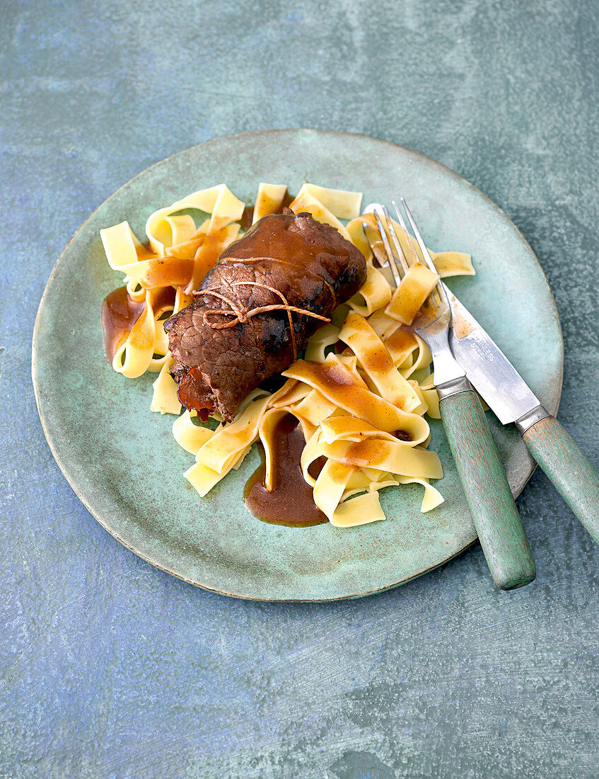 Beef rolls with noodles on plate