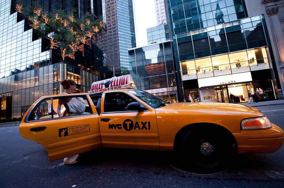 Woman getting in taxi at Times Square in New York, USA