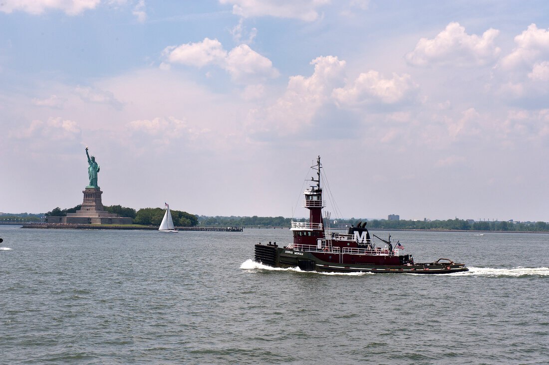 Statue of Liberty in front of boat in sea, New York